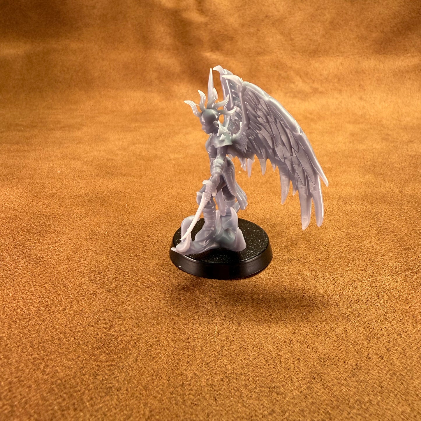 Fantasy figurine with wings on a brown surface