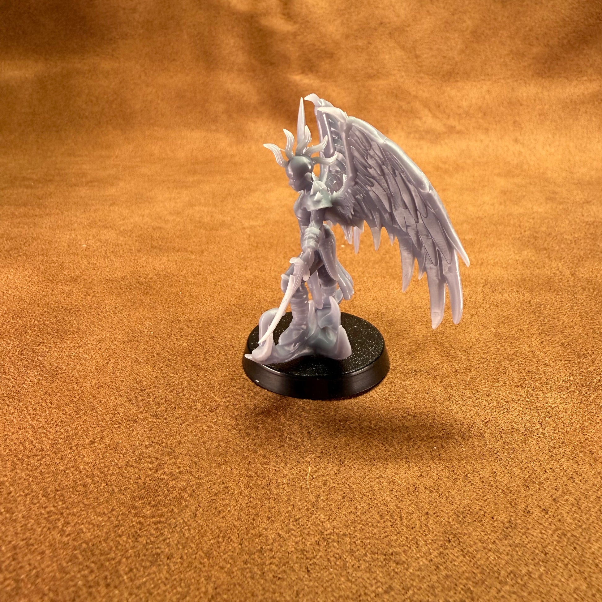 Fantasy figurine with wings on a brown surface