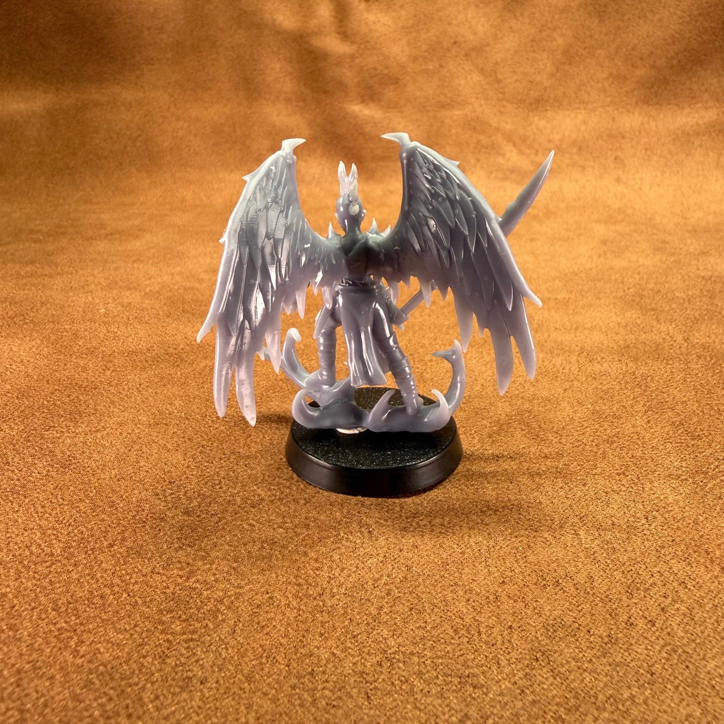 Fantasy figurine with wings on a brown surface