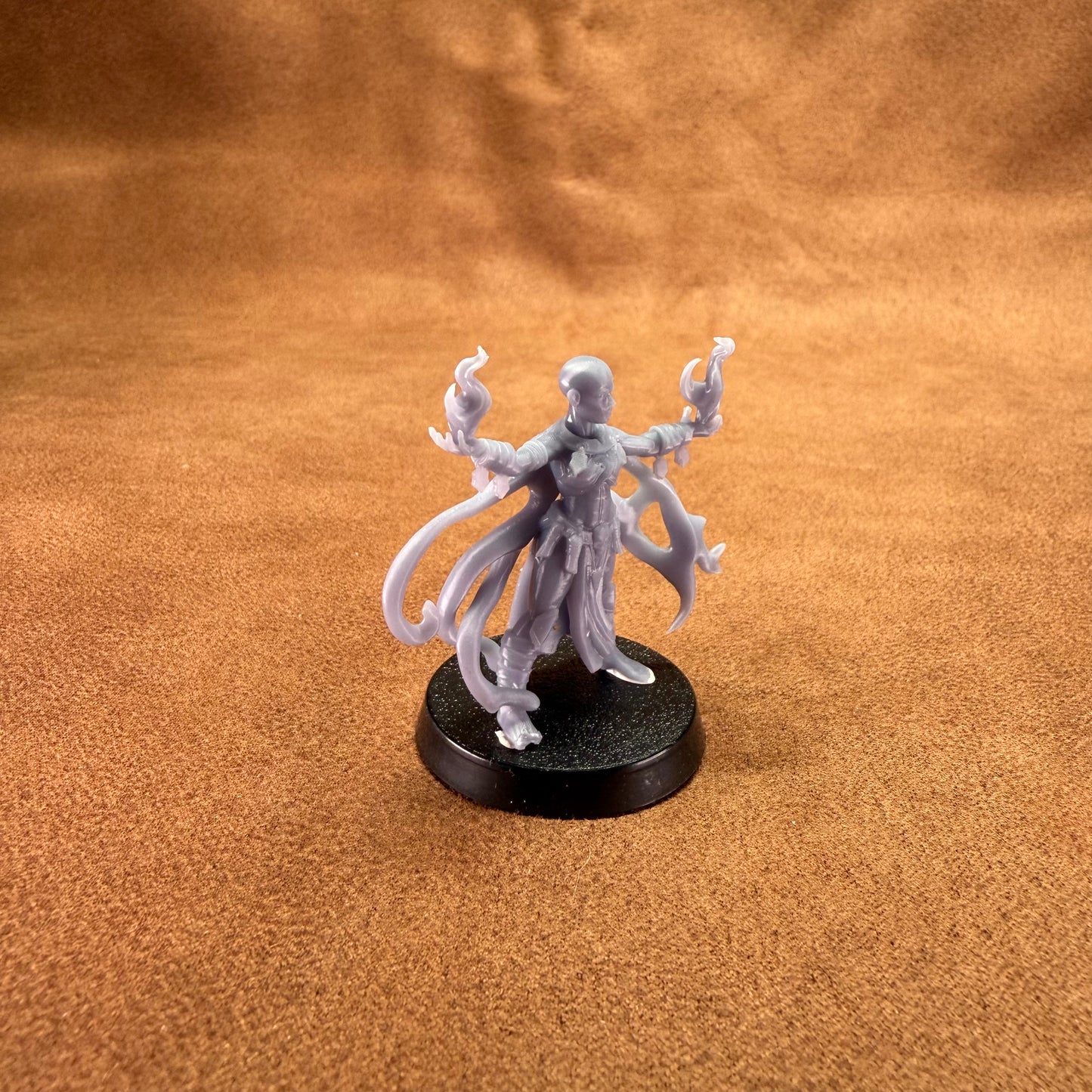 Gray fantasy figurine on a brown textured surface