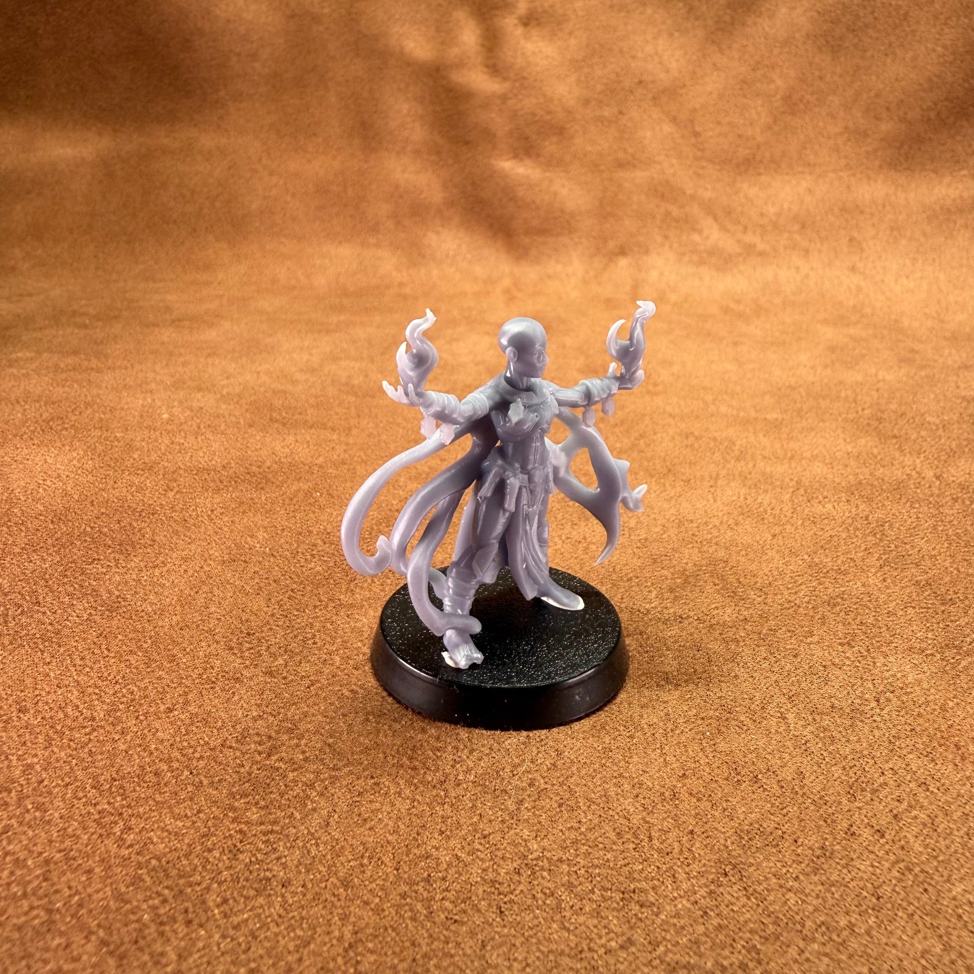 Gray fantasy figurine on a brown textured surface
