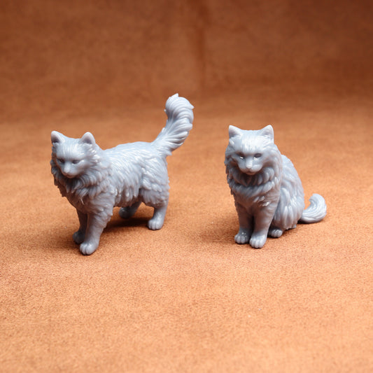 pair of grey cat miniatures on a brown surface