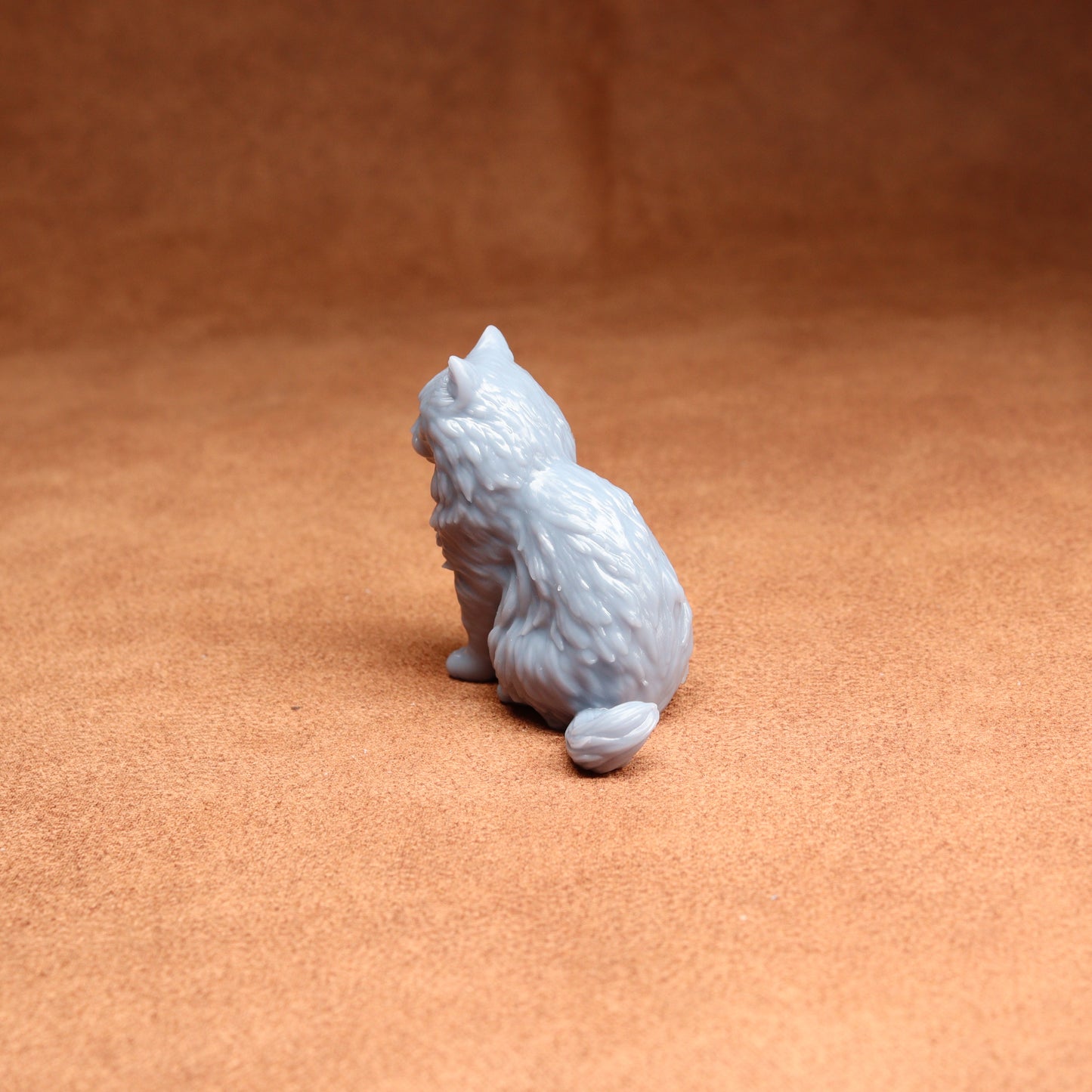 Gray cat figurine on a brown surface