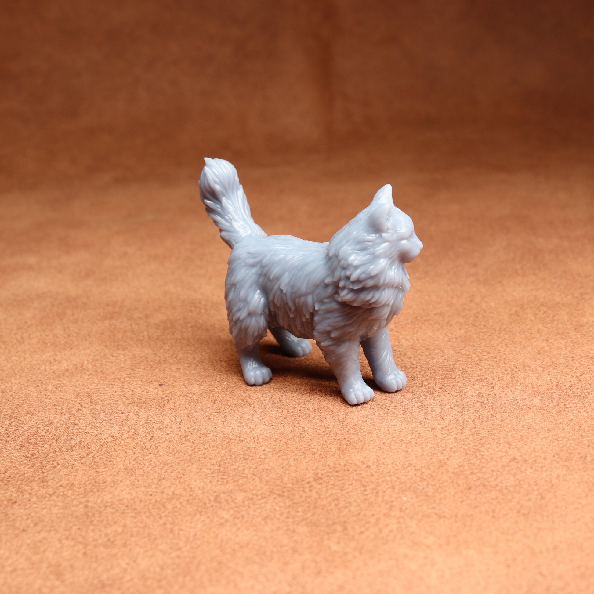 Gray cat figurine on a brown surface