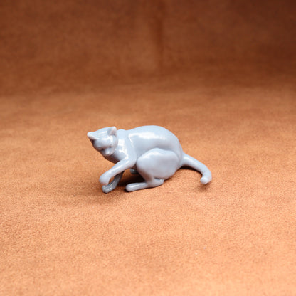 White ceramic cat figurine on a brown surface