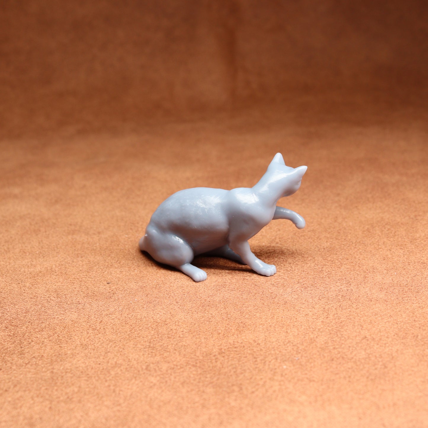 White ceramic cat figurine on a brown surface