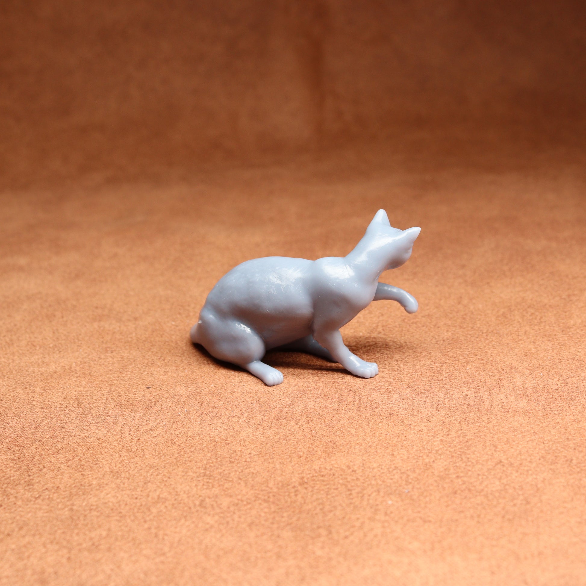 White ceramic cat figurine on a brown surface