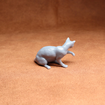 White ceramic cat figurine on a brown surface