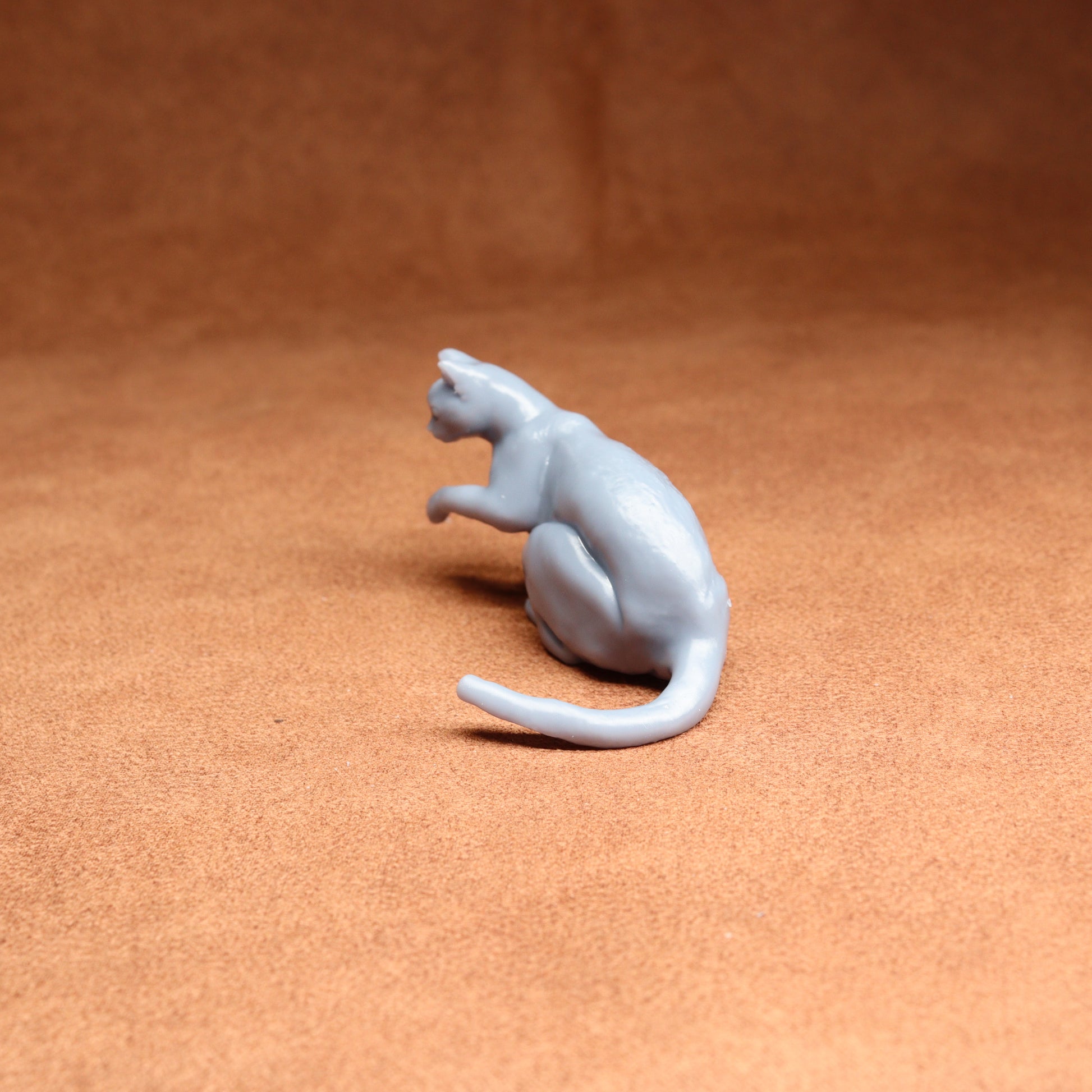 White ceramic cat figurine on a brown surface