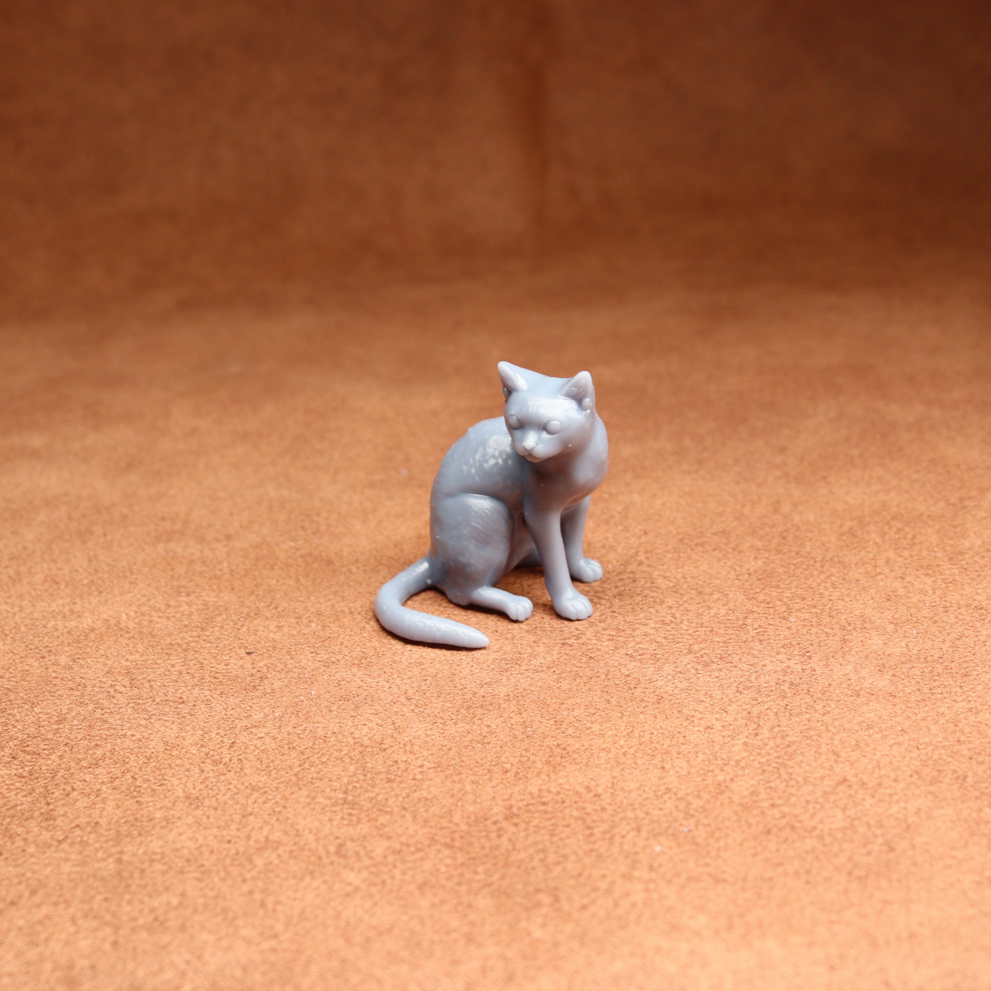 Gray cat figurine on a brown surface