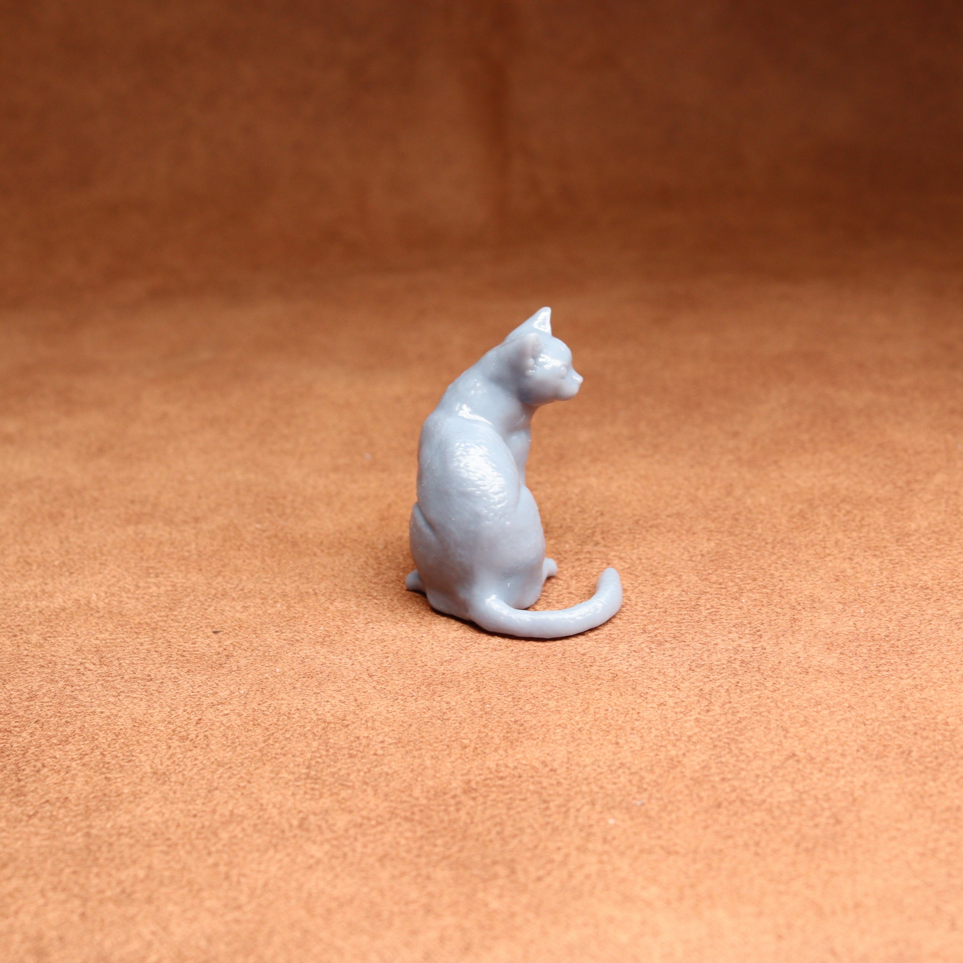 White cat figurine on a brown surface
