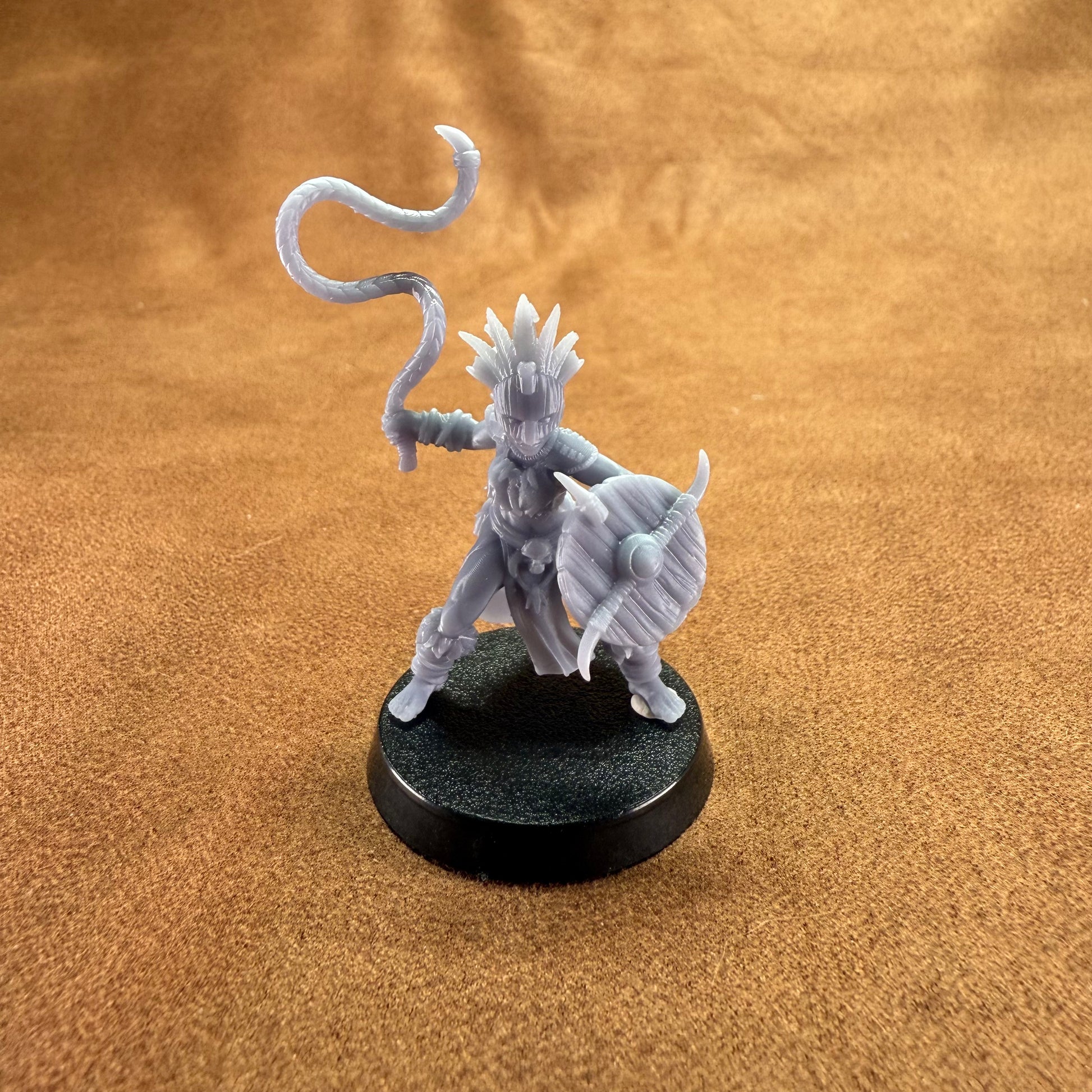 Gray fantasy figurine on a black base against a brown textured background