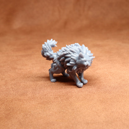 grey resin cat miniature on a brown surface