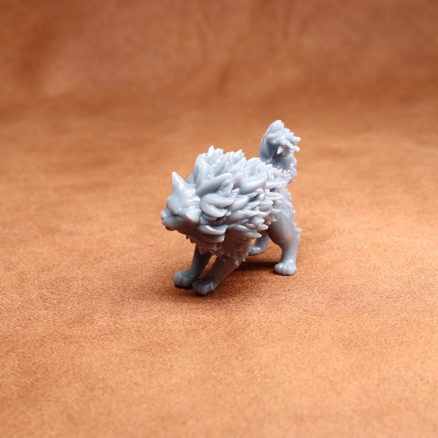 grey resin cat miniature on a brown surface