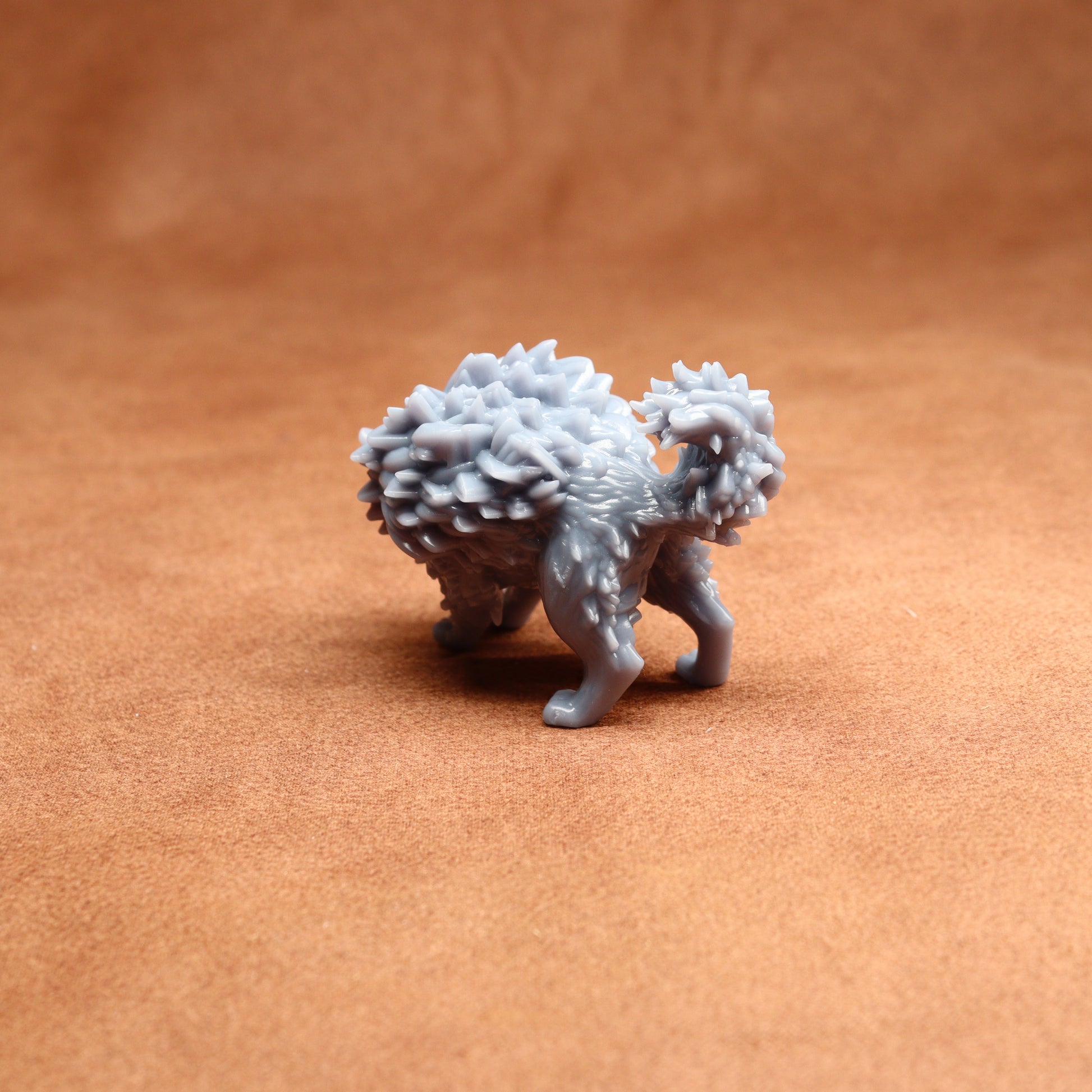 grey resin cat miniature on a brown surface