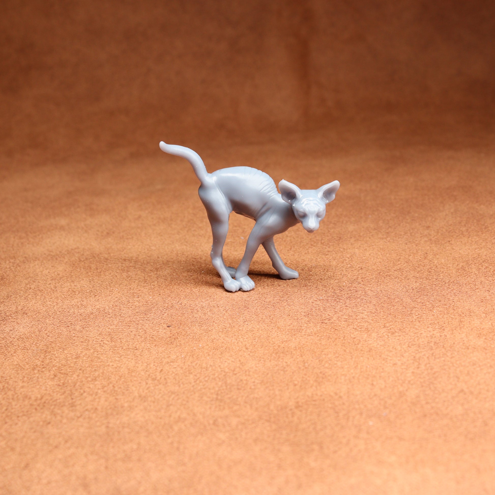 White cat figurine on a brown surface