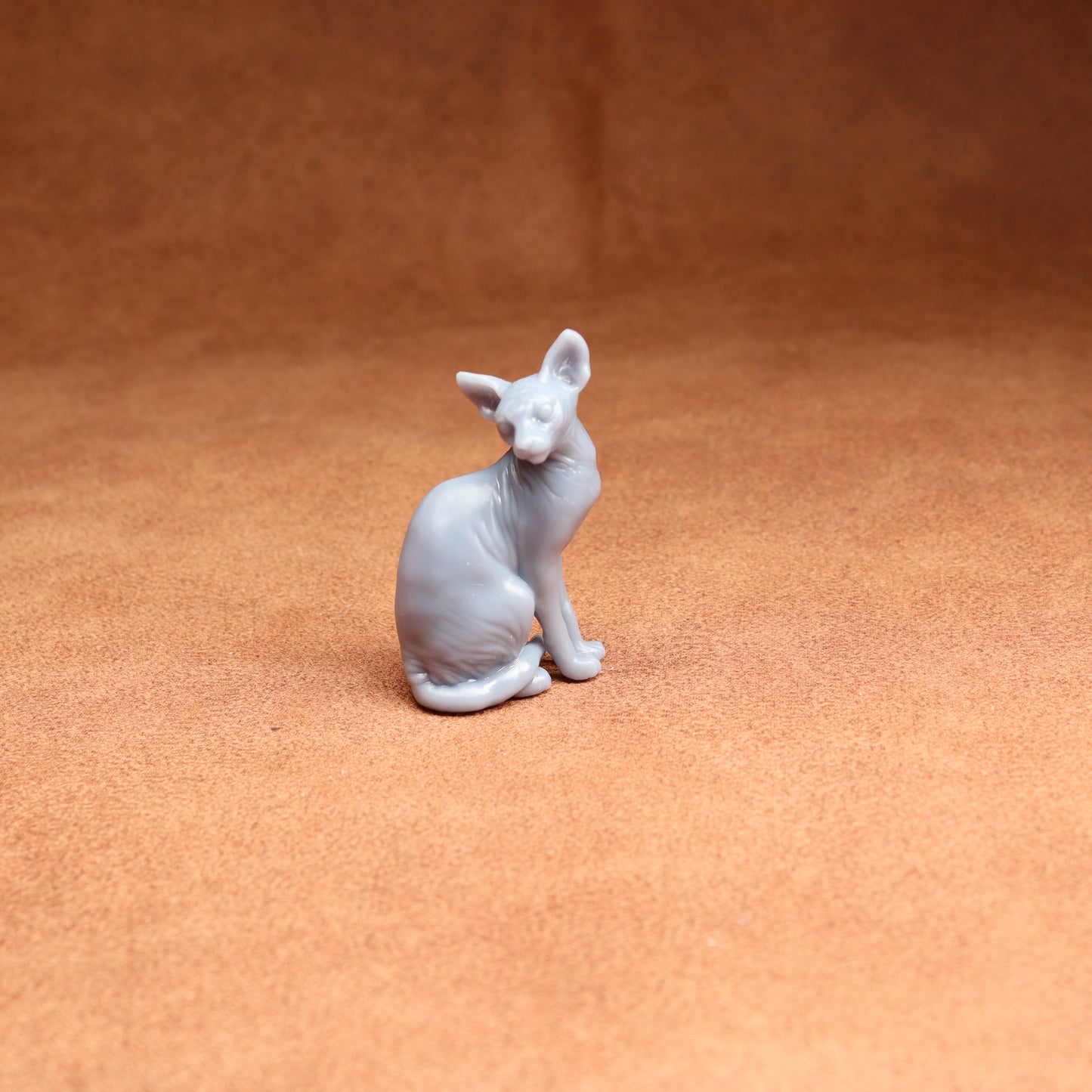 White cat figurine on a brown surface