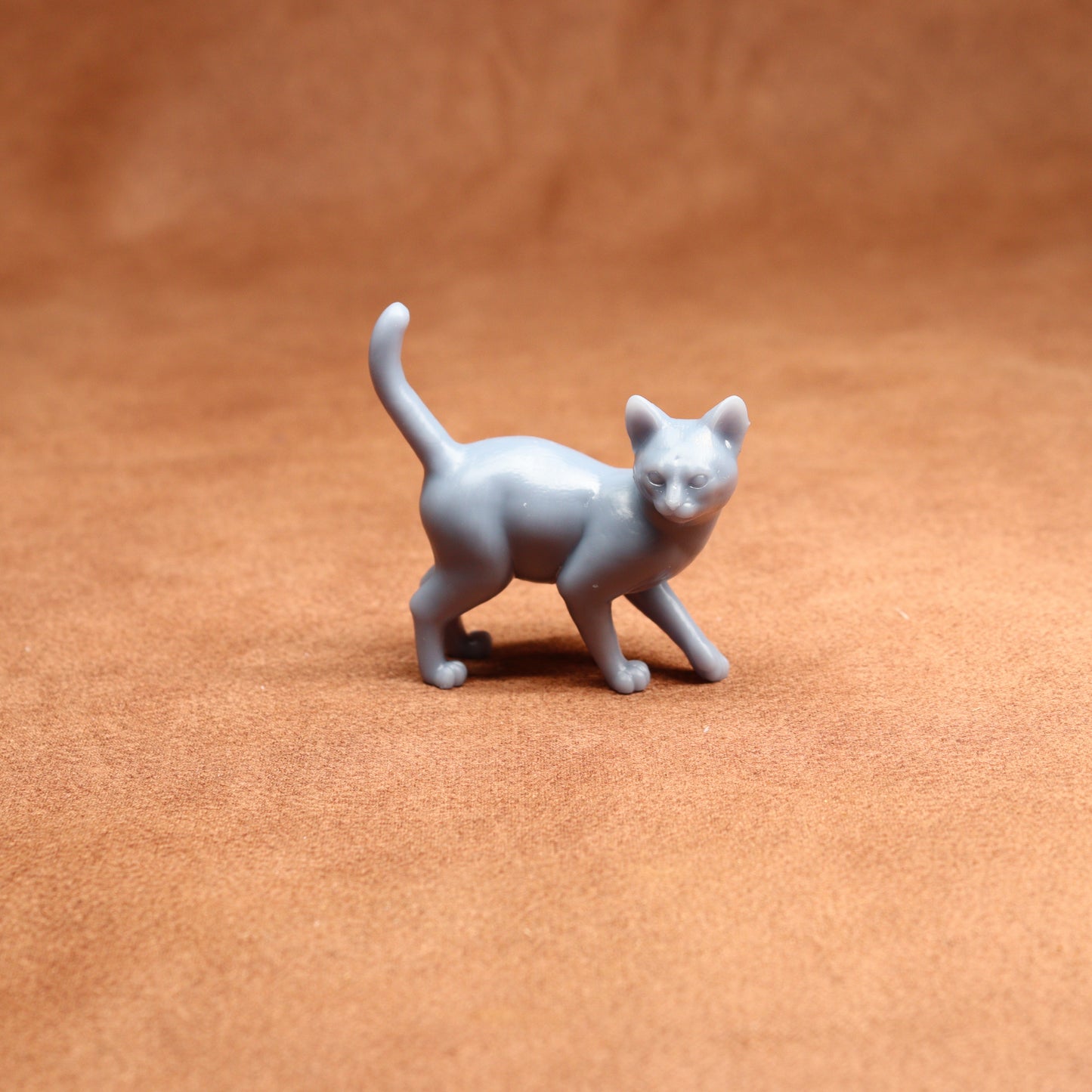 Gray cat figurine on a brown surface