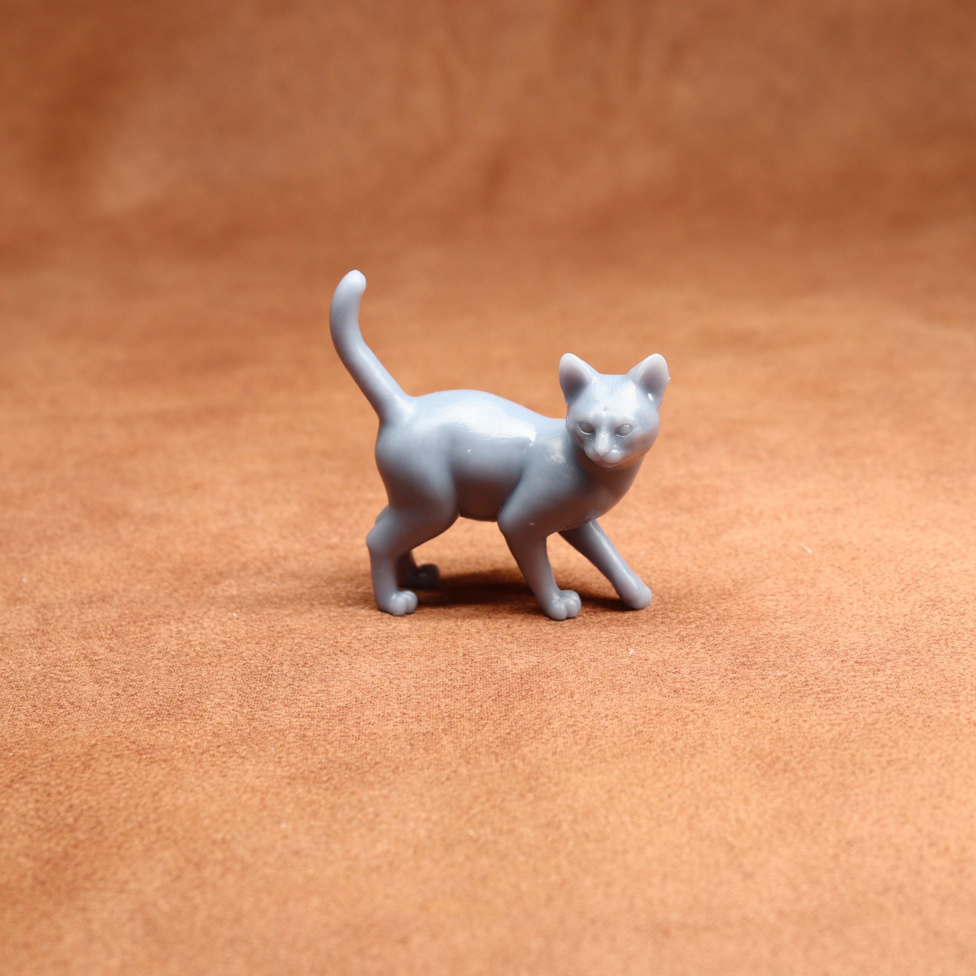 Gray cat figurine on a brown surface