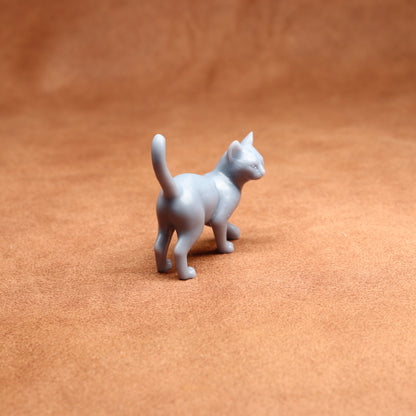 Small gray cat figurine on a brown surface