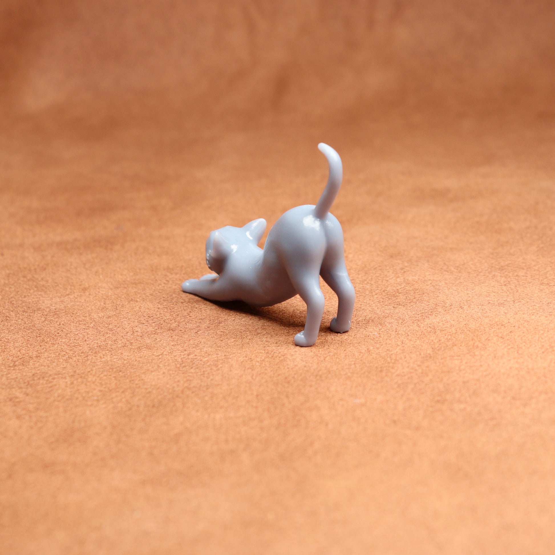 White cat figurine on a brown leather surface