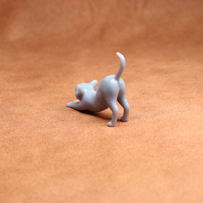 White cat figurine on a brown leather surface