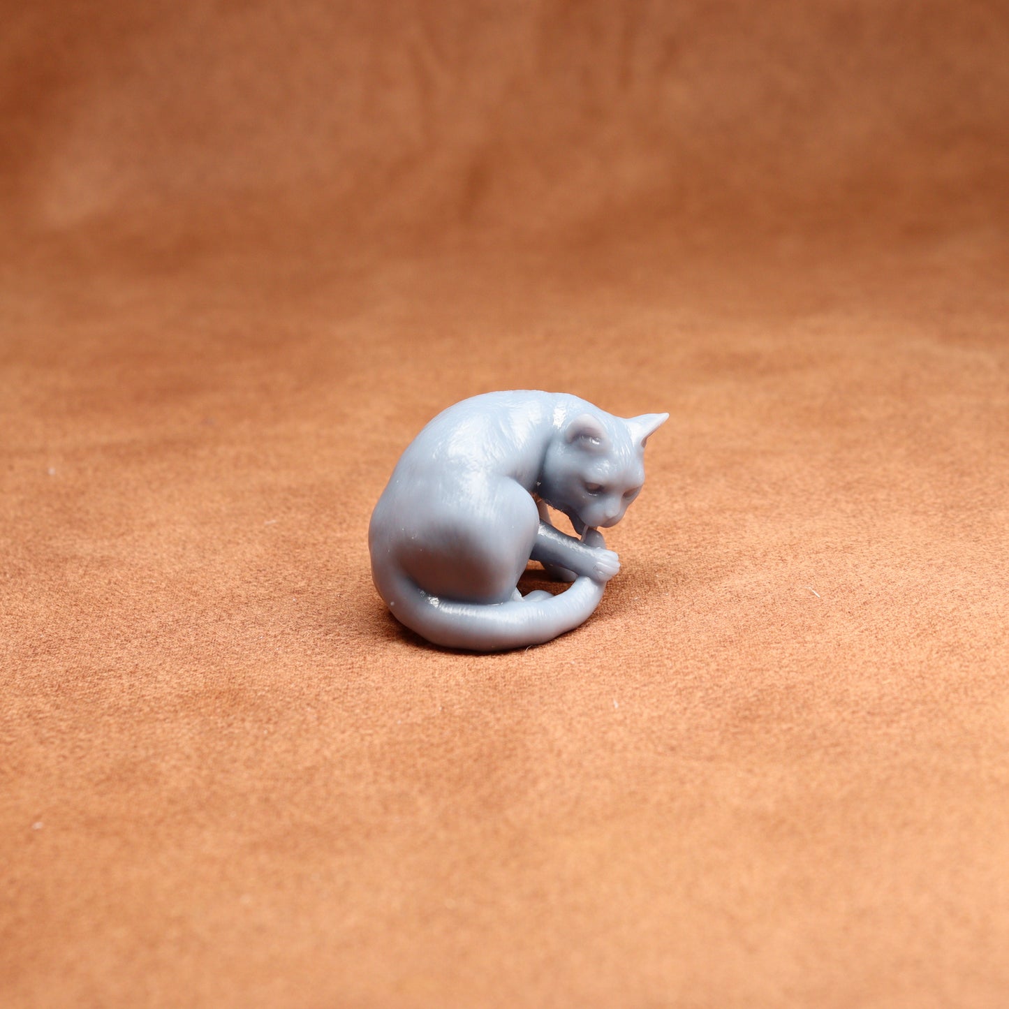 grey resin cat miniature on a brown surface