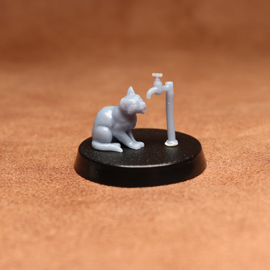 grey cat resin miniature on a black base on a brown background.