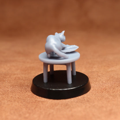 grey cat resin miniature on a black base on a brown background.