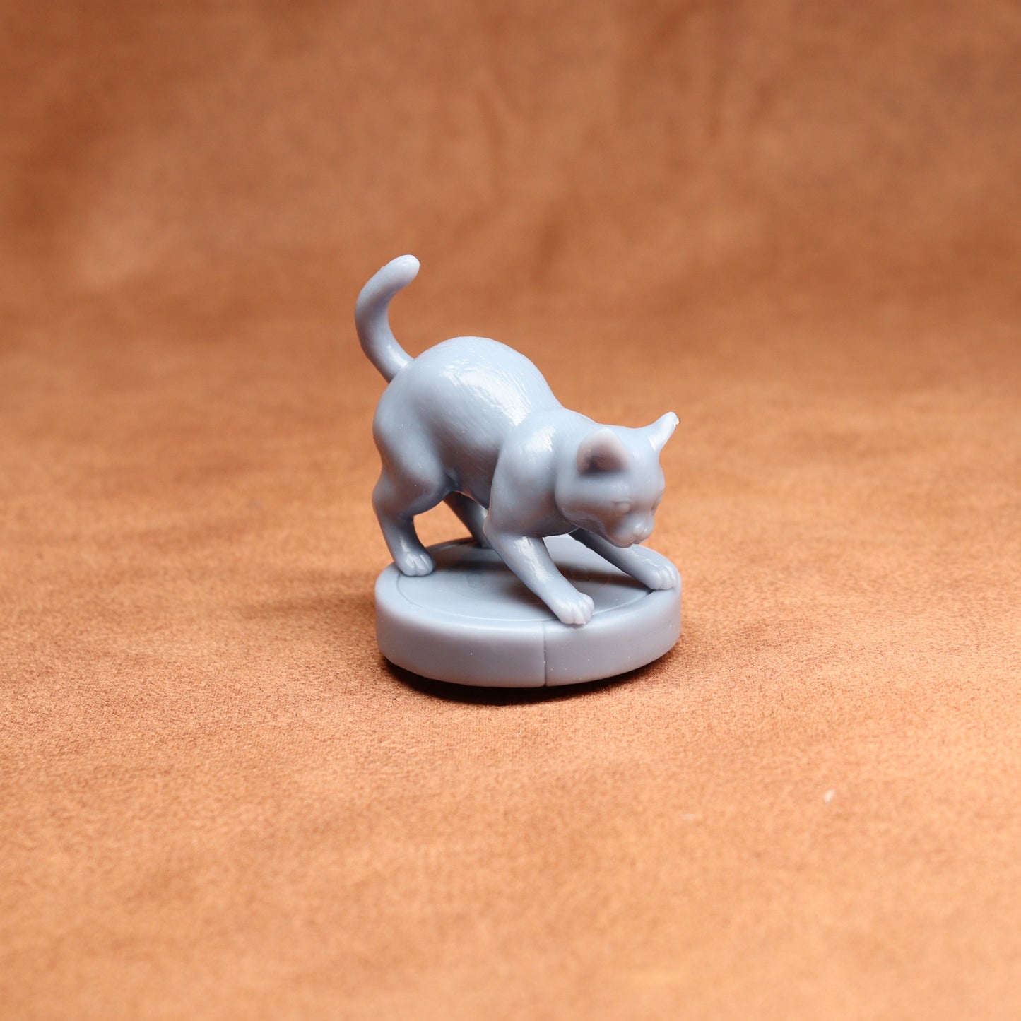 Gray cat figurine on a brown surface