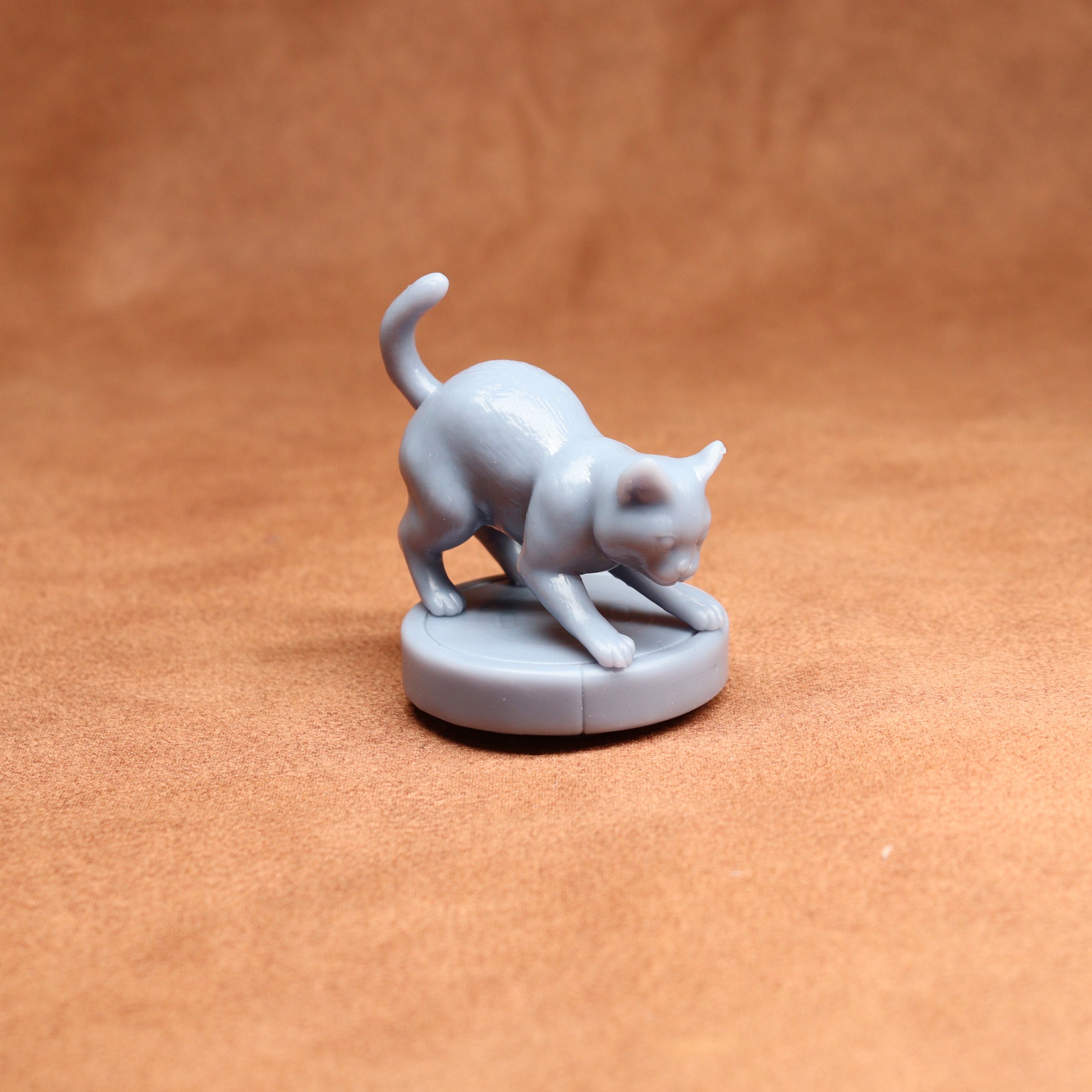 Gray cat figurine on a brown surface