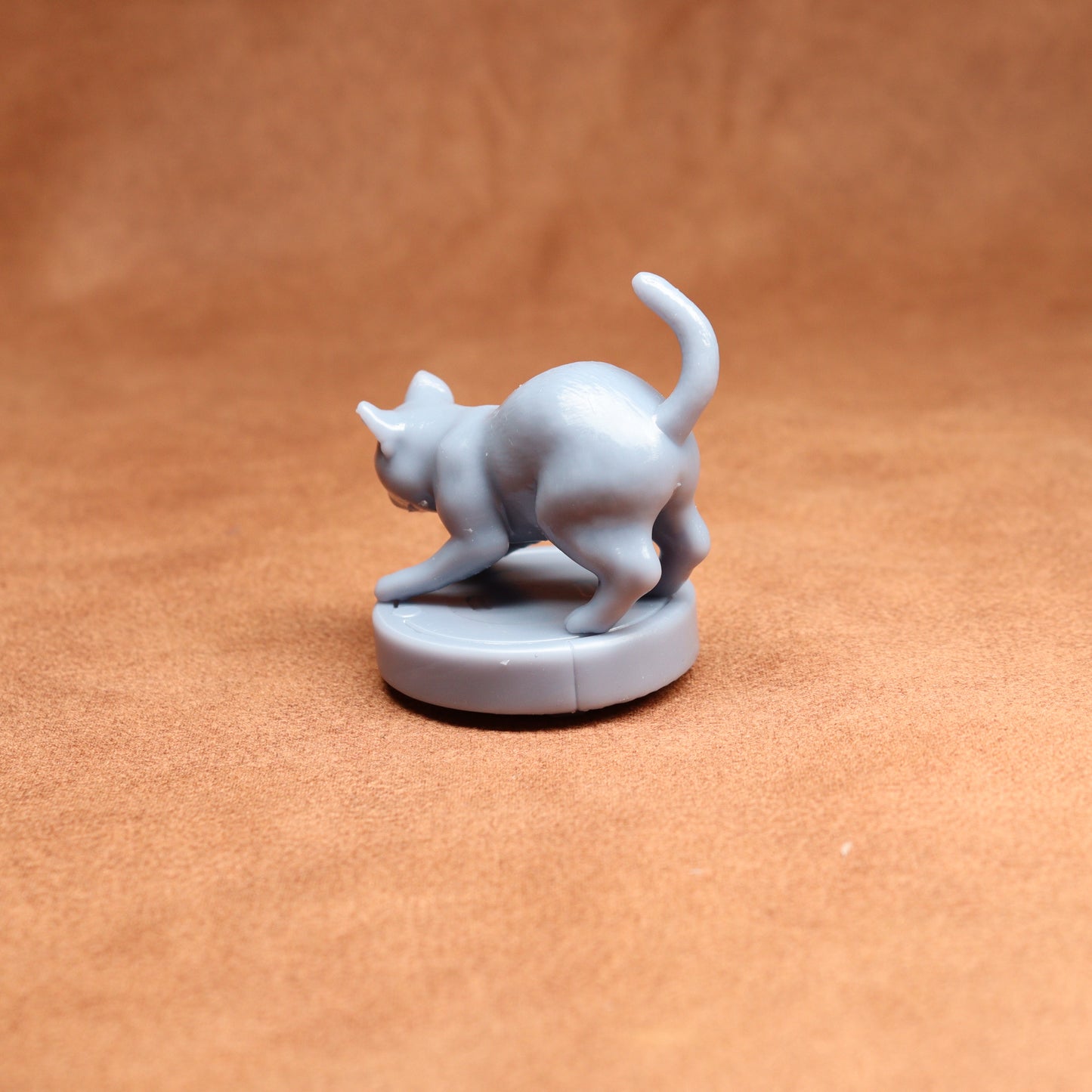 Gray cat-shaped figurine on a brown surface