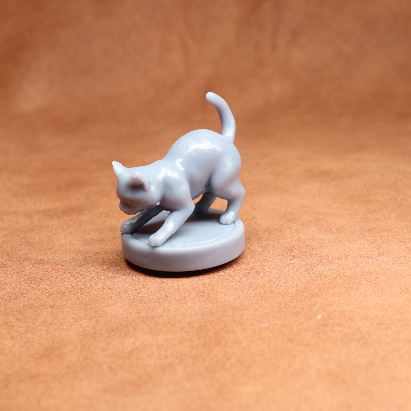 White ceramic cat figurine on a brown surface