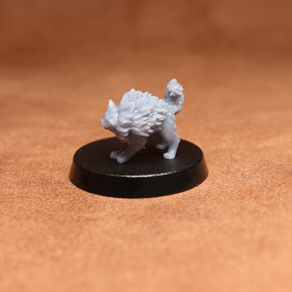 grey cat resin miniature on a black base on a brown background.