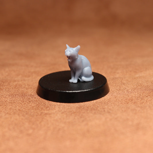 grey cat resin miniature on a black base on a brown background.