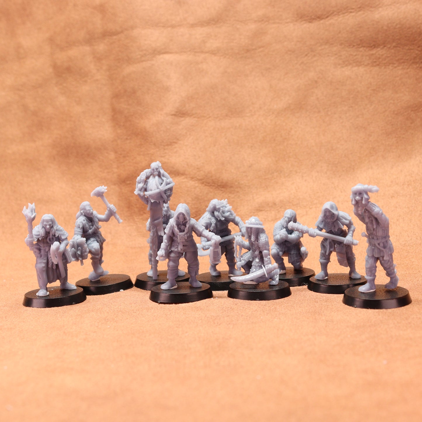 Set of gray miniature figures on black bases against a brown leather background