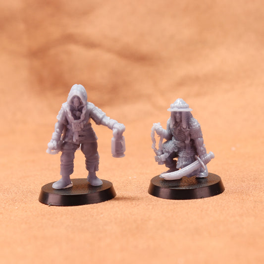 Two miniature figures on round bases against a brown background