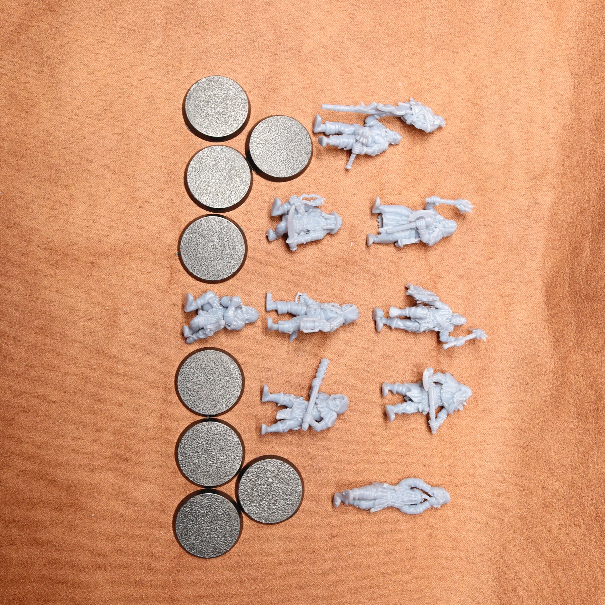 Small scale model figures and round metallic objects on a brown surface